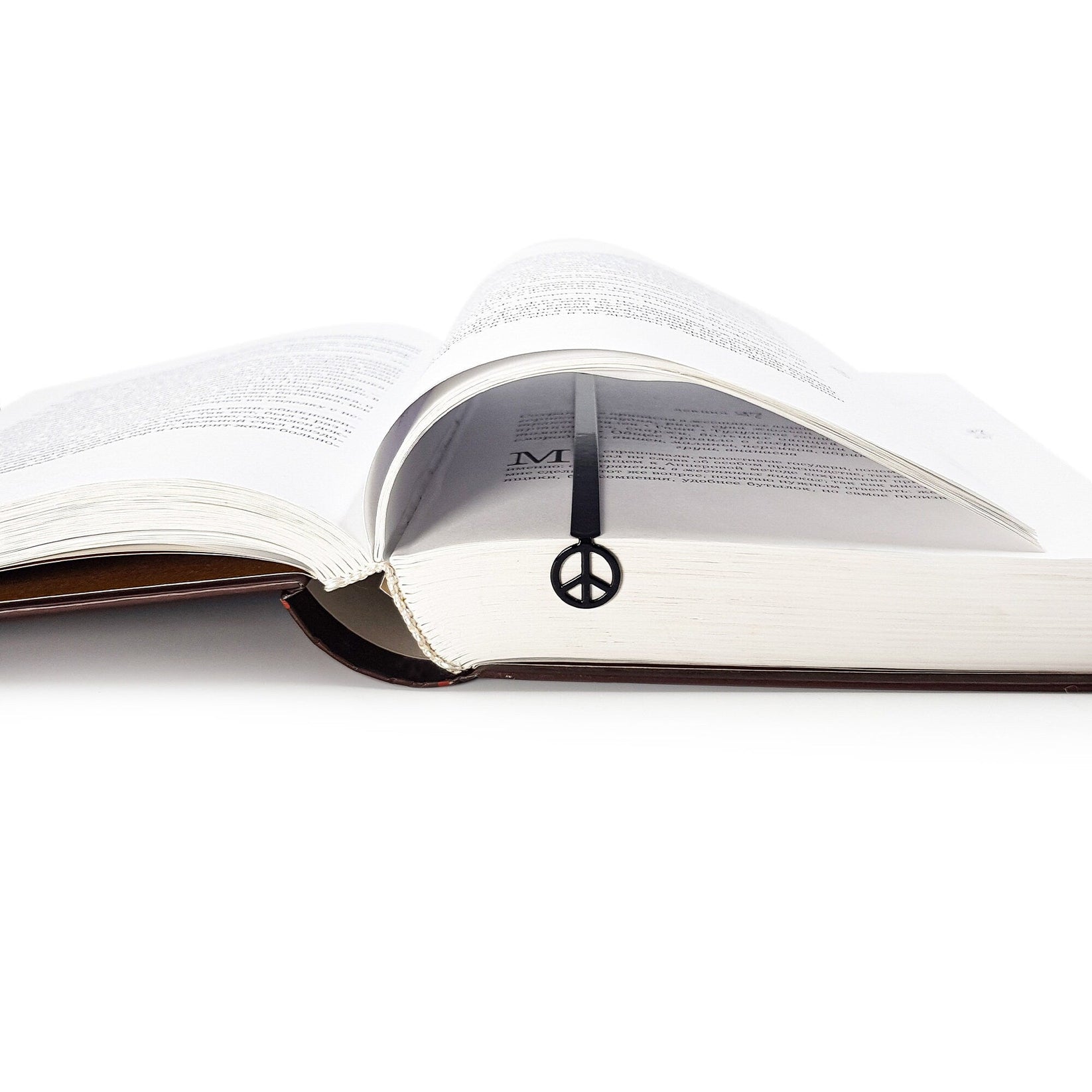 Peace metal bookmark resting on the pages of an open book