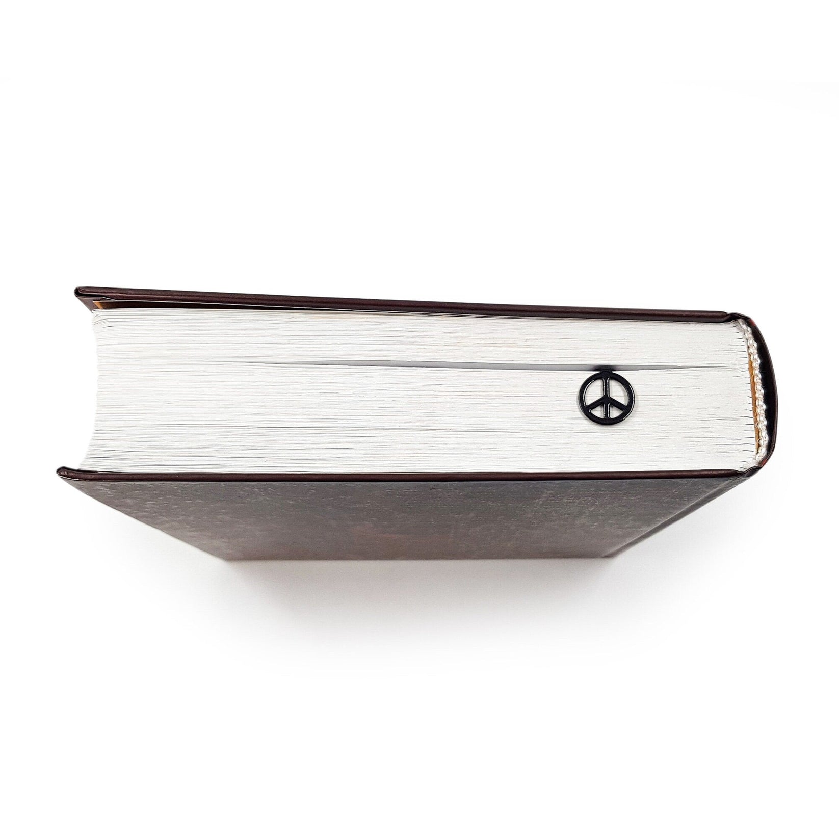Peace metal bookmark in a closed book, only its top showing above the pages