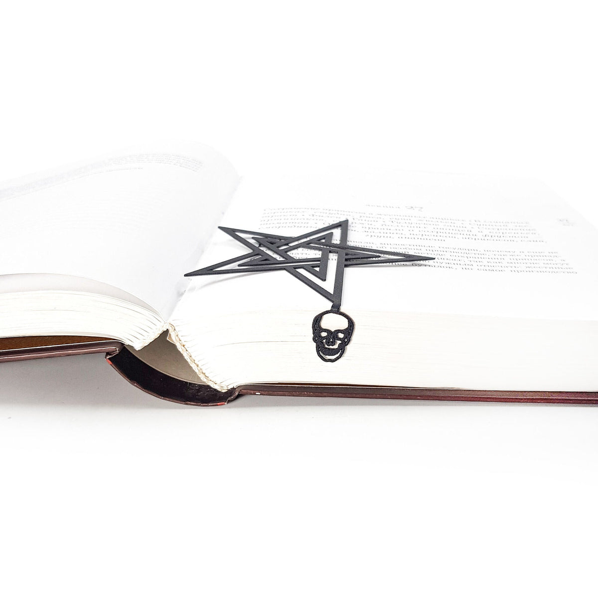 Pentagram & Skull metal bookmark marking a page in an open book