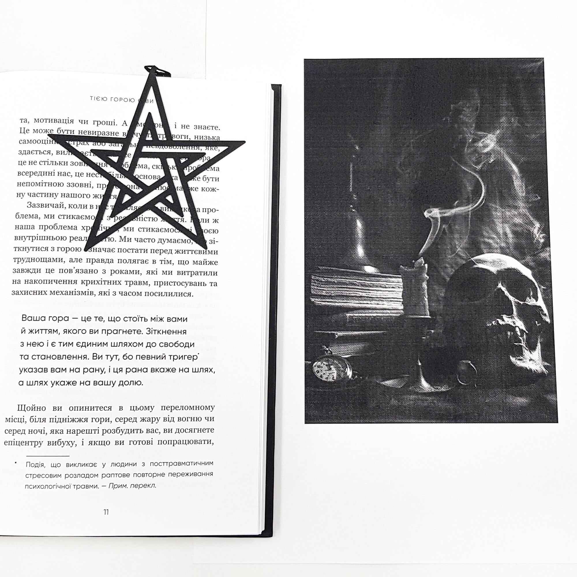 Book page with a black star bookmark and a black and white photograph of a skull and candle.