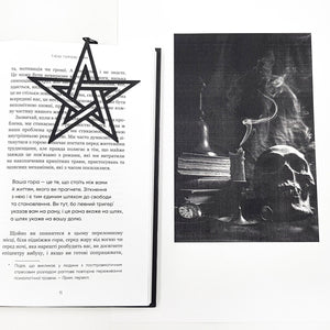 Book page with a black star bookmark and a black and white photograph of a skull and candle.