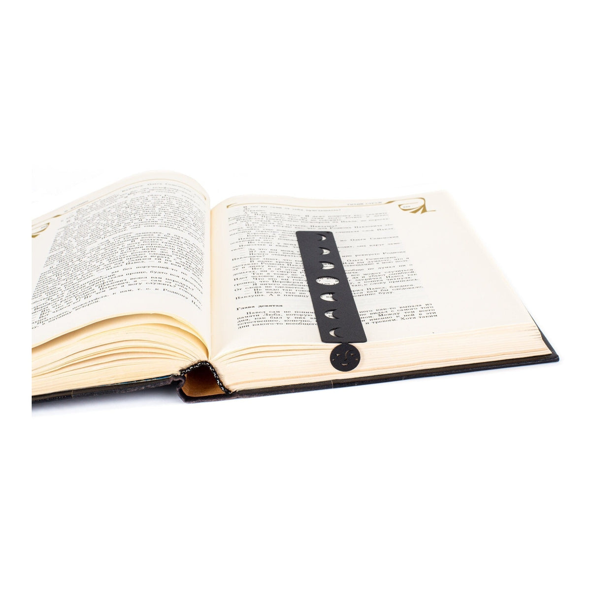 Phases of the Moon metal bookmark resting on the pages of an open book