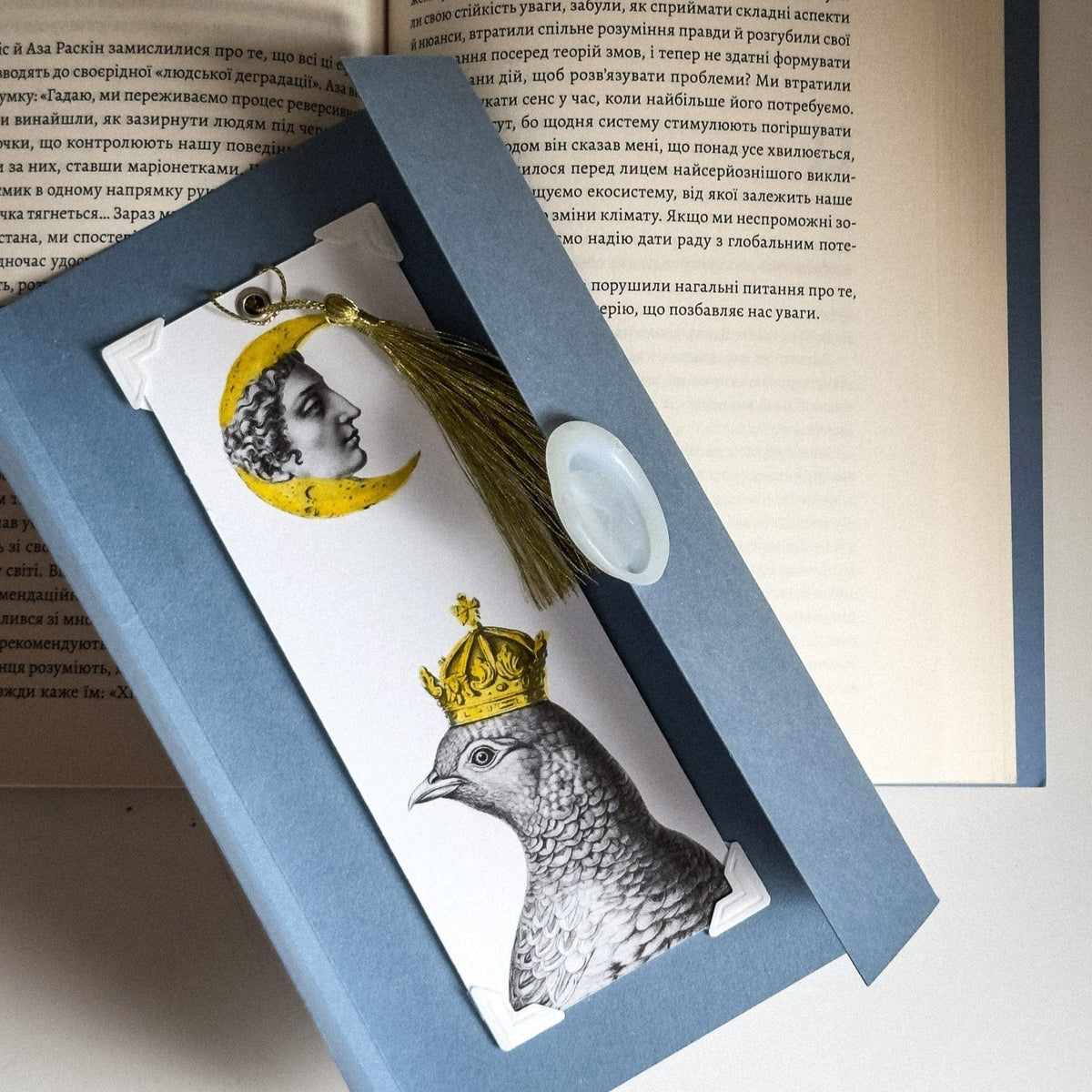 Pigeon Queen and The Moon metal bookmark on a coloured background