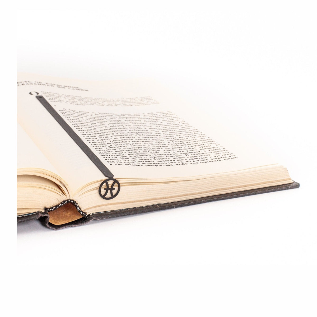 Pisces metal bookmark resting on the pages of an open book