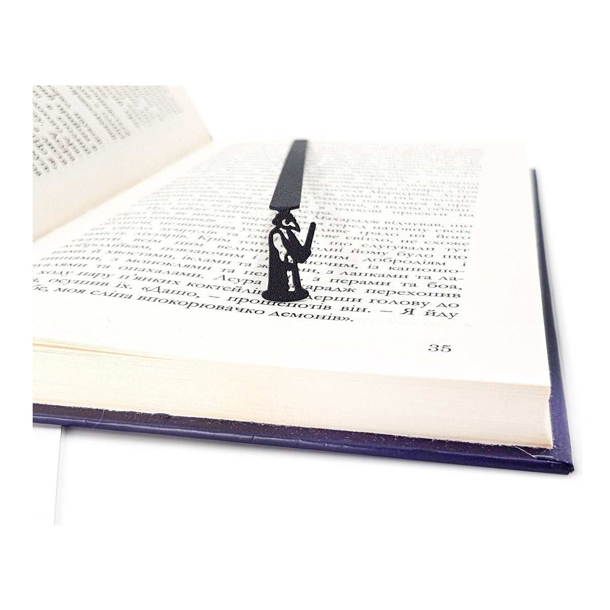 Plaque Death Doctor metal bookmark resting on the pages of an open book