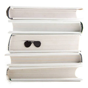 Police Sunglasses metal bookmark shown with a stack of books