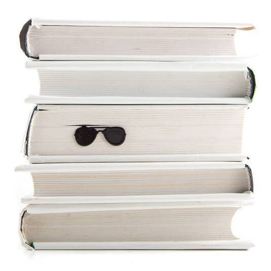 Police Sunglasses metal bookmark shown with a stack of books
