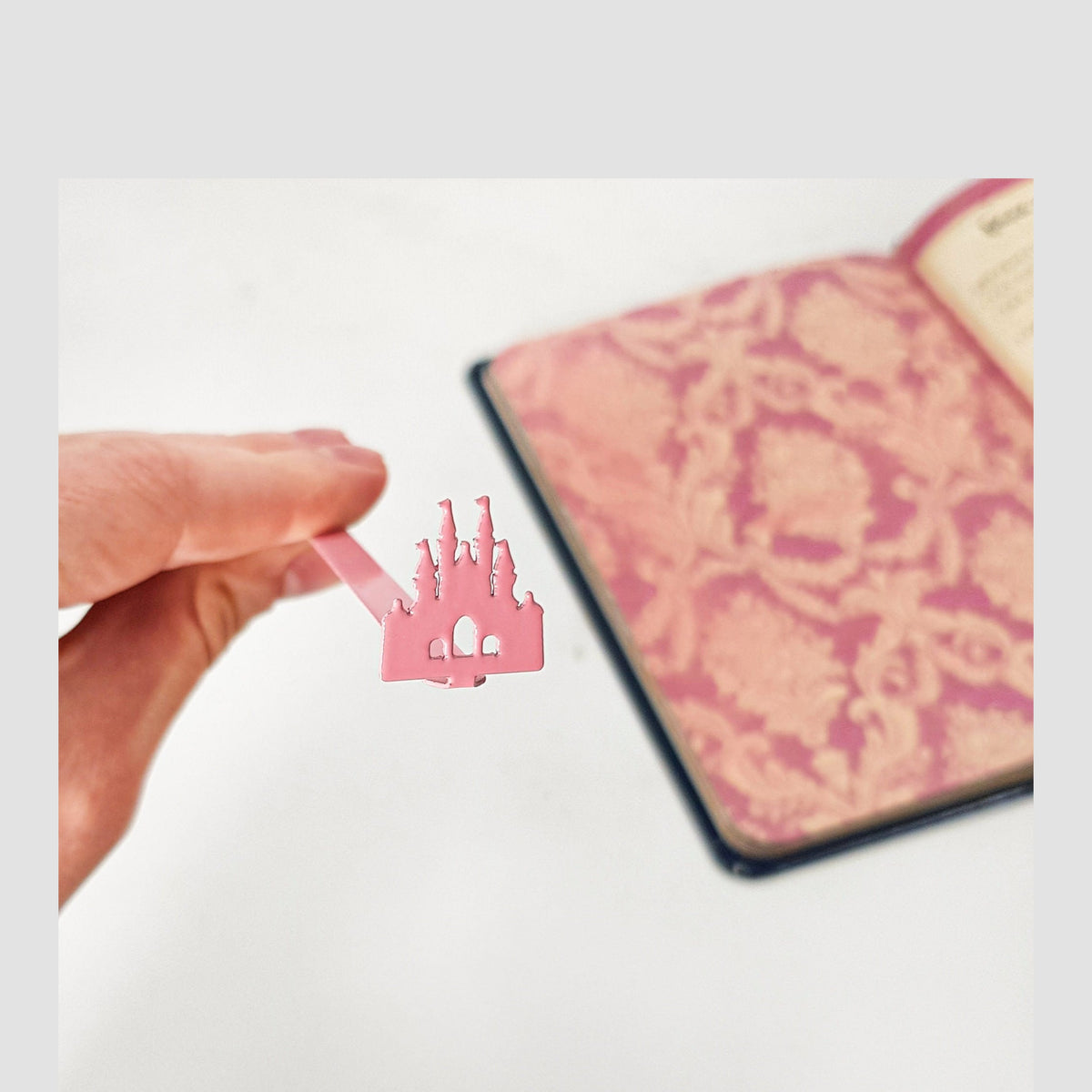 Princess Castle Pink metal bookmark in red on a coloured background
