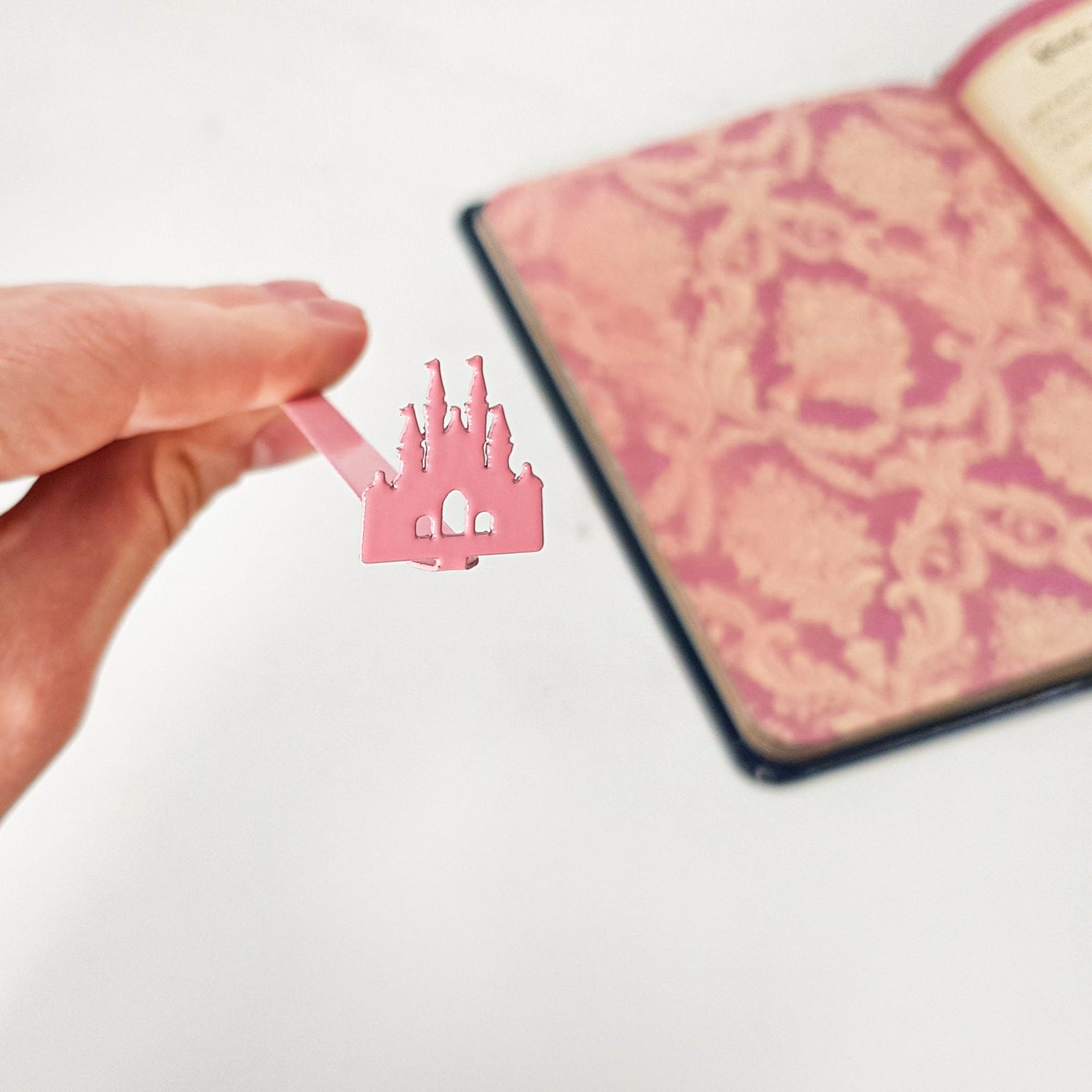 Princess Castle Pink metal bookmark in red on a coloured background