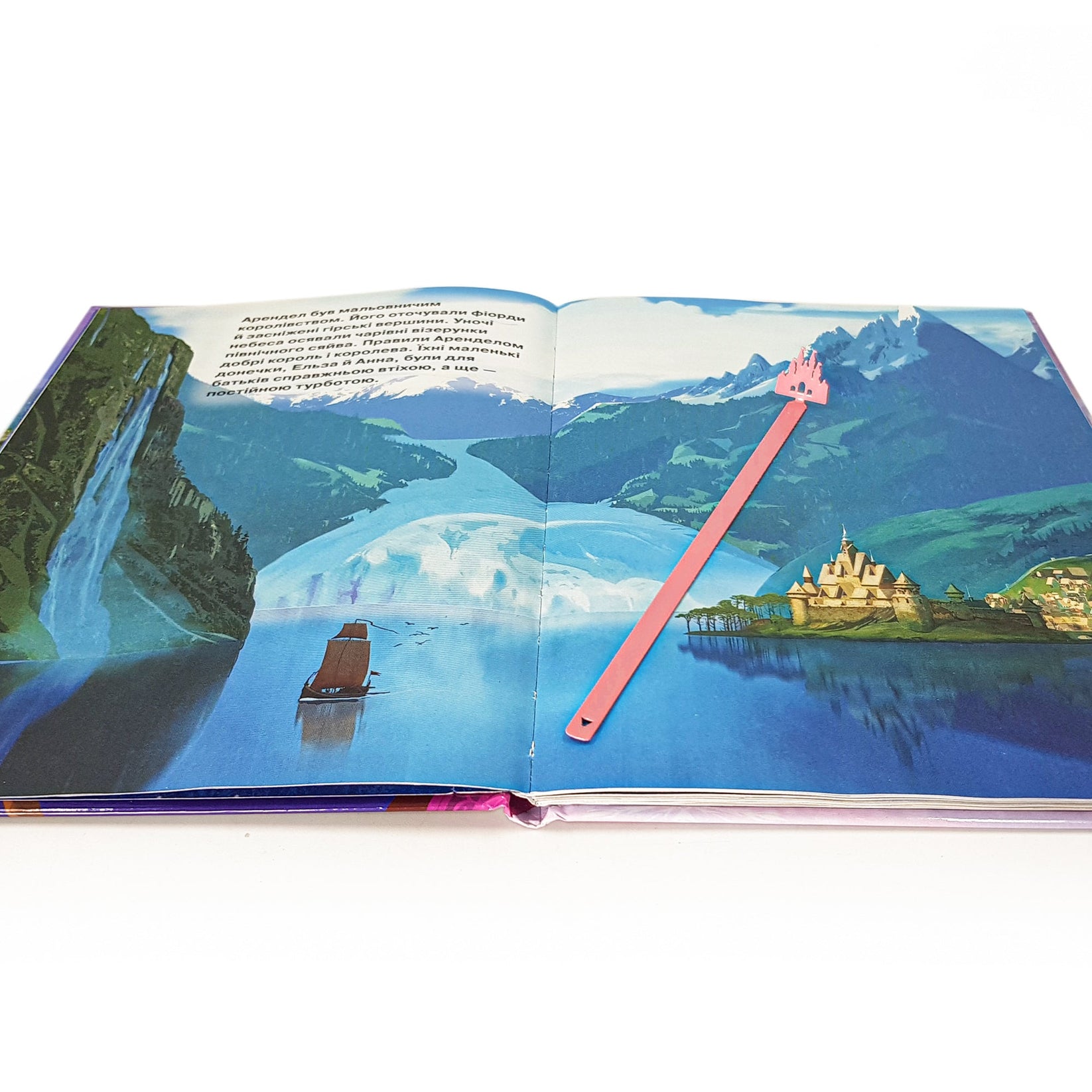 Princess Castle Pink metal bookmark in red marking a page in an illustrated book
