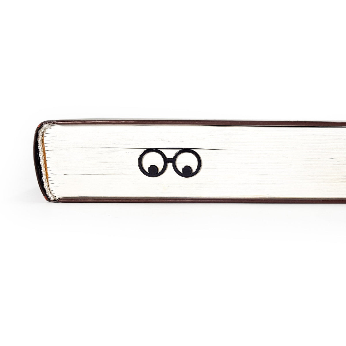 Reading Eyes metal bookmark in a closed book, only its top showing above the pages