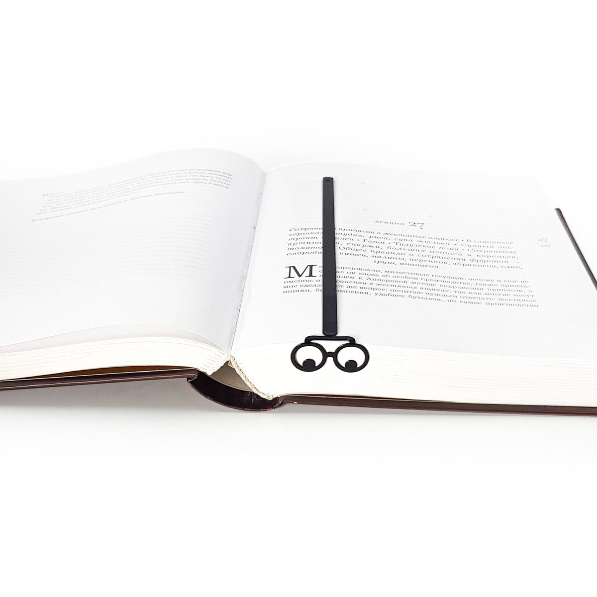 Reading Eyes metal bookmark marking a page in an open book