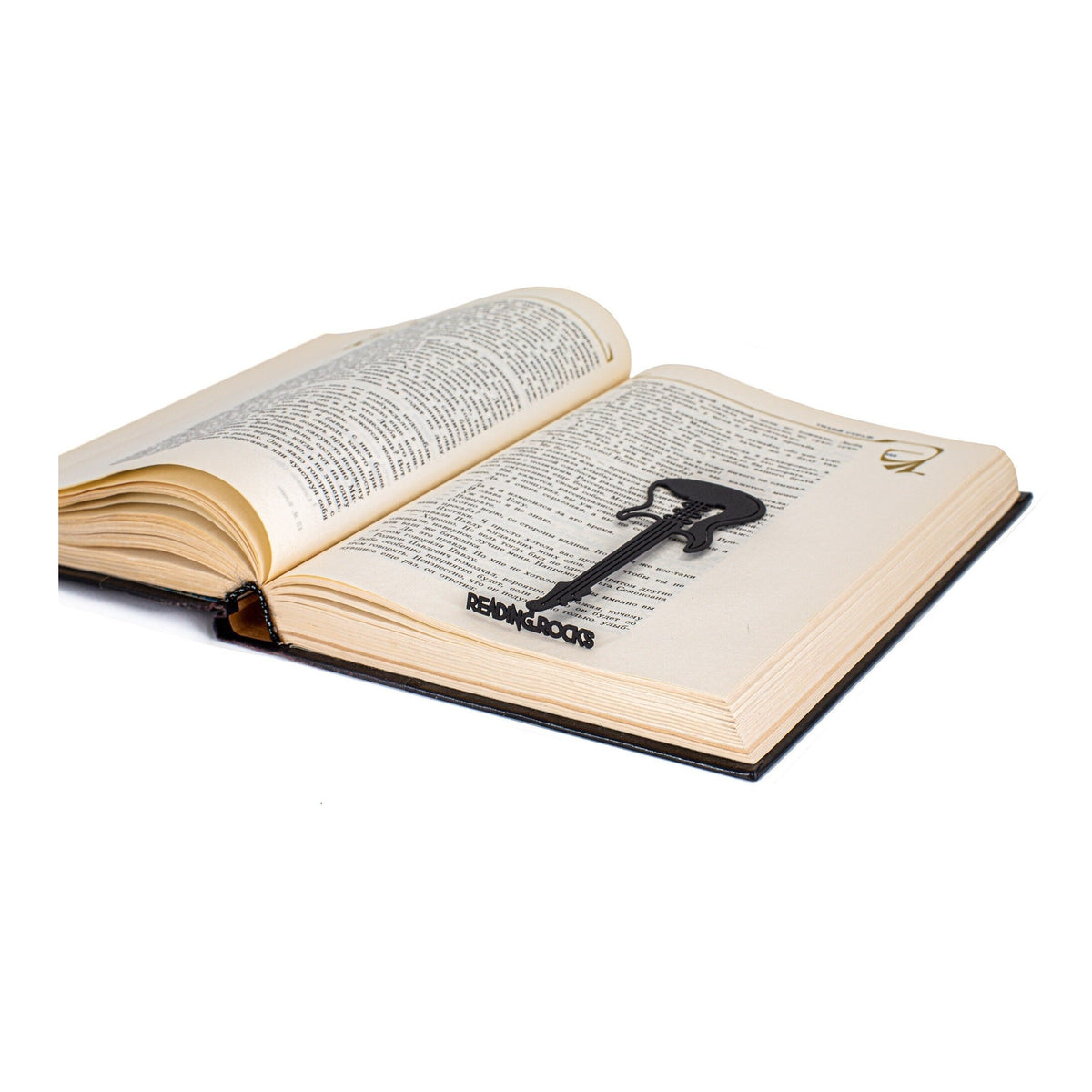 Reading Rocks metal bookmark resting on the pages of an open book