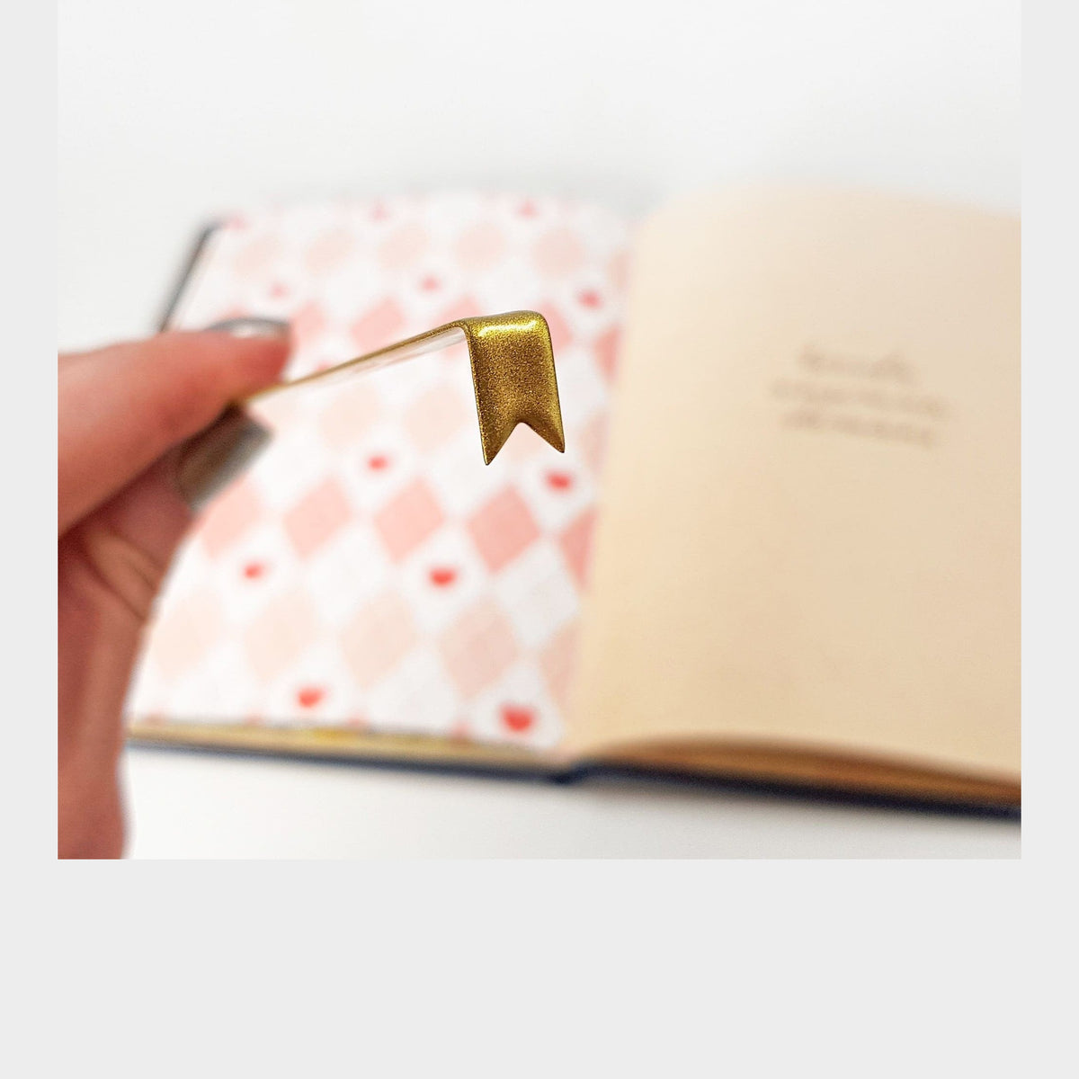 Ribbon metal bookmark in gold on a coloured background