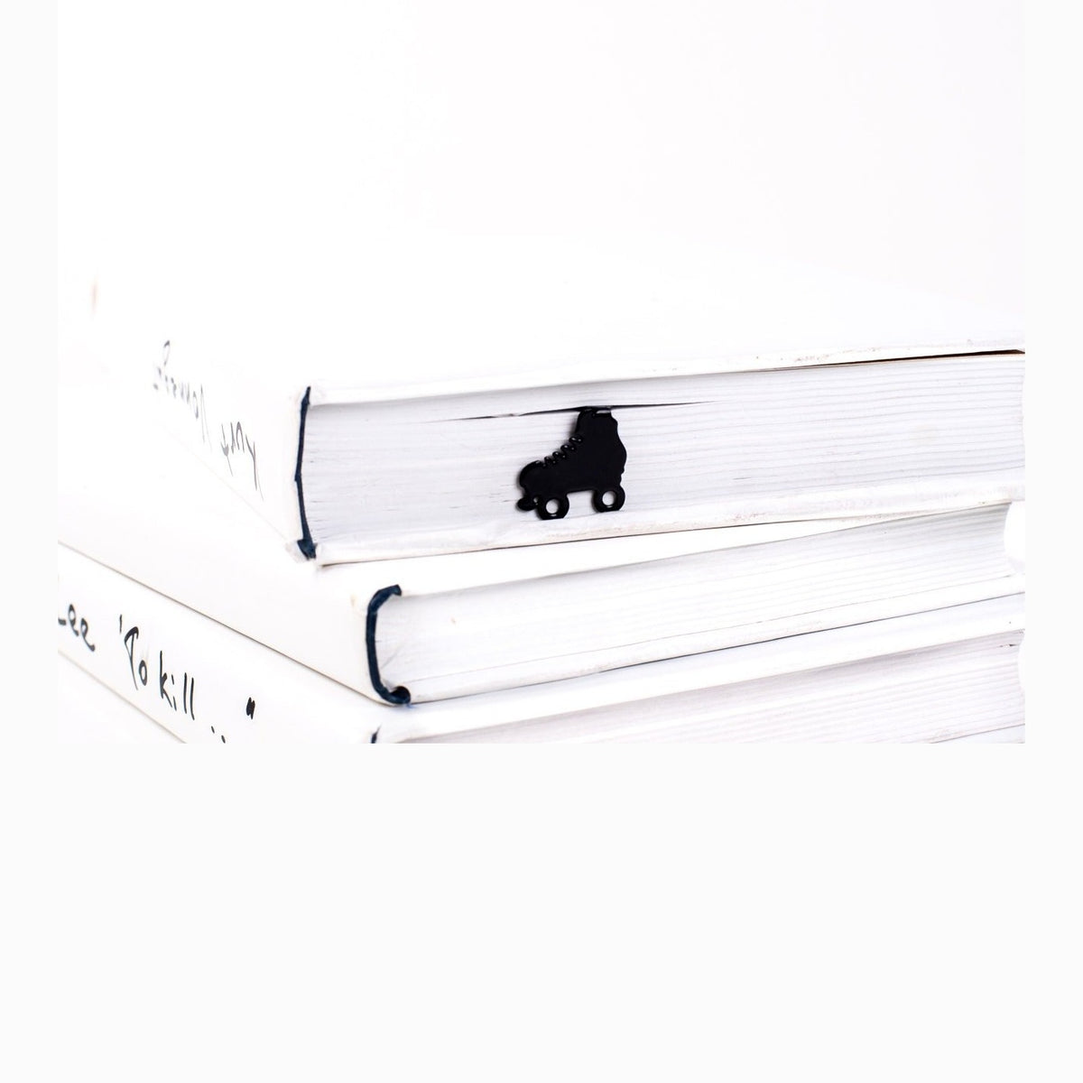 Roller Skates metal bookmark in a closed book, only its top showing above the pages