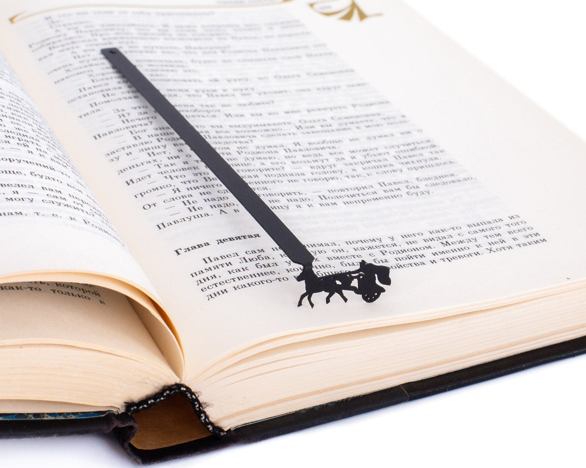 Roman Chariot metal bookmark resting on the pages of an open book