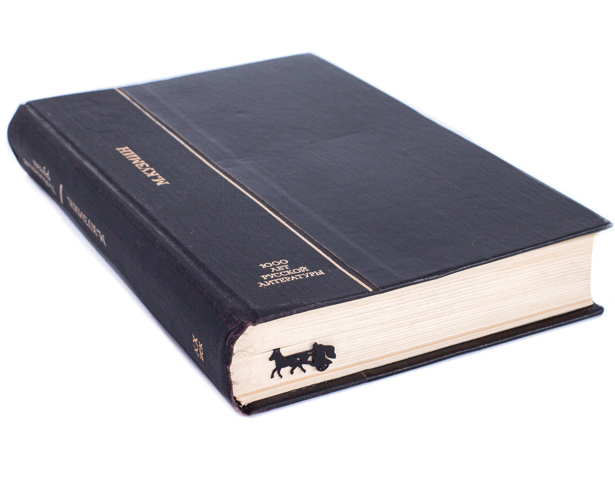 Roman Chariot metal bookmark clipped in a closed book, viewed from the side