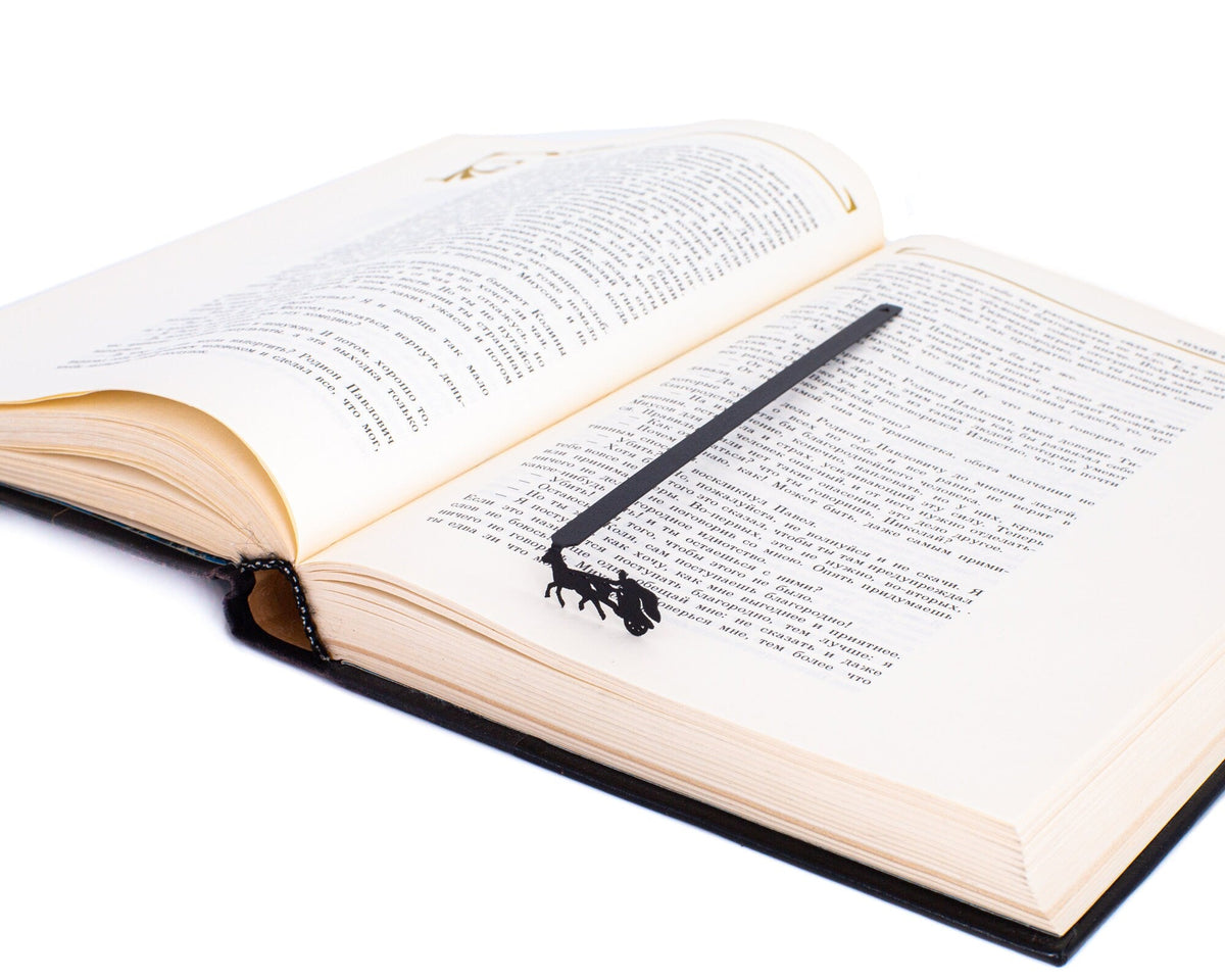 Roman Chariot metal bookmark marking a page in an open book
