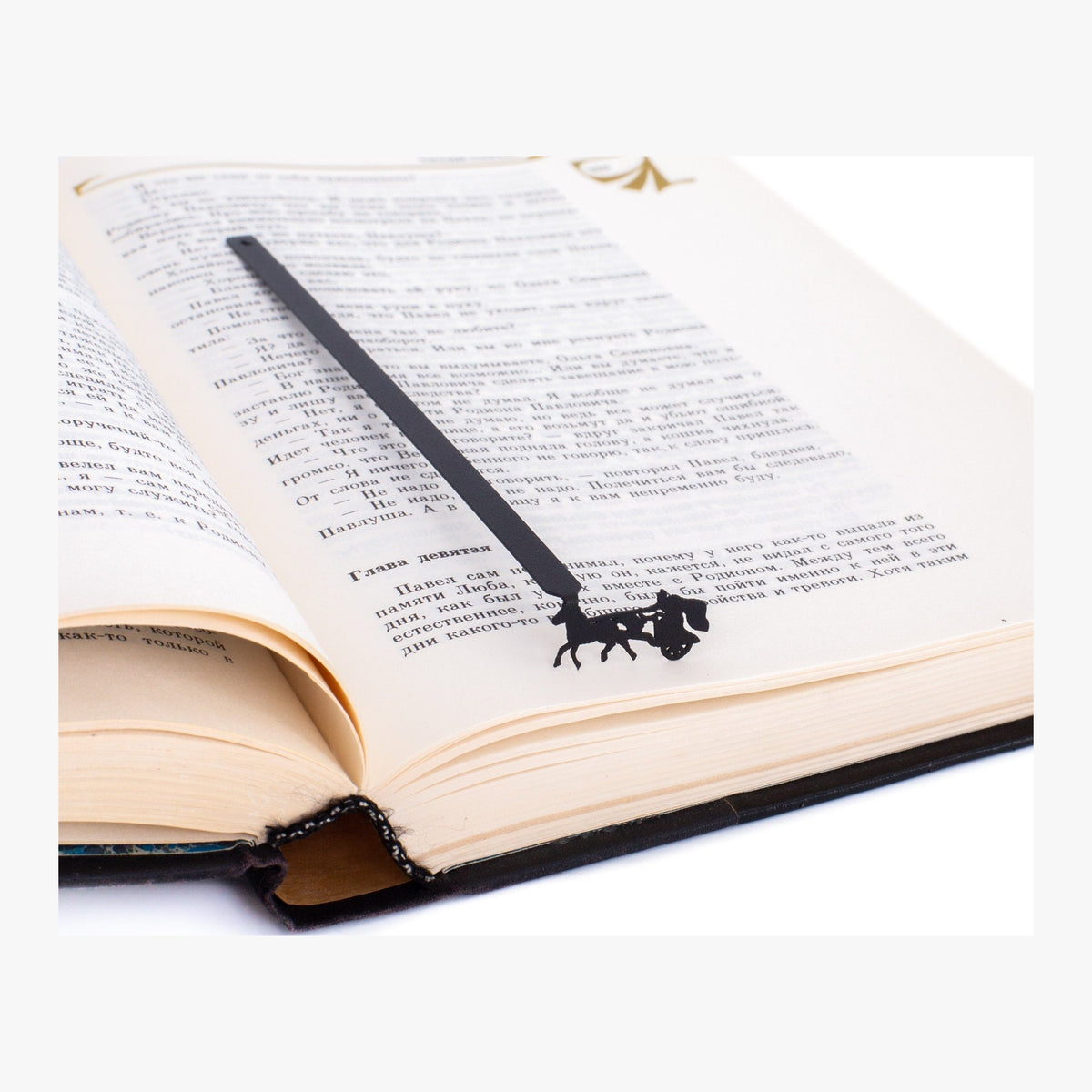 Roman Chariot metal bookmark resting on the pages of an open book
