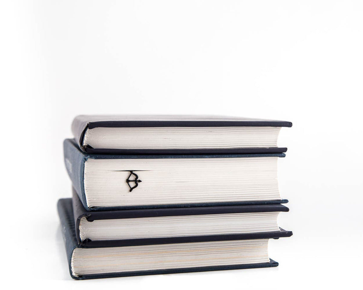 Sagittarius metal bookmark shown with a stack of books