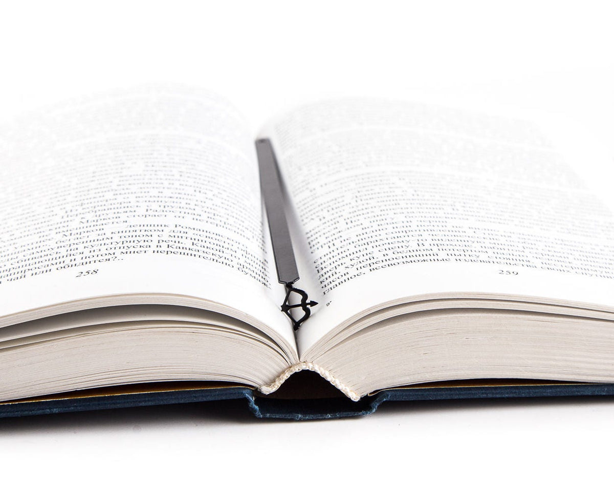 Sagittarius metal bookmark marking a page in an open book