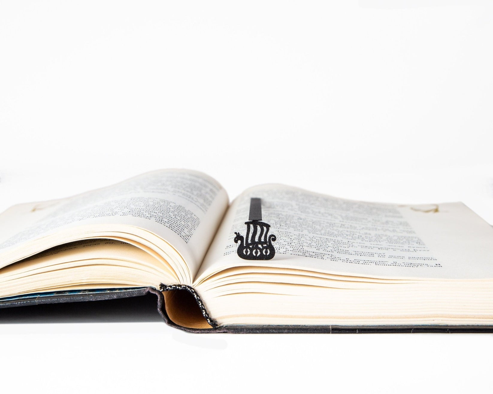 Scandinavian Vikings Ship metal bookmark resting on the pages of an open book