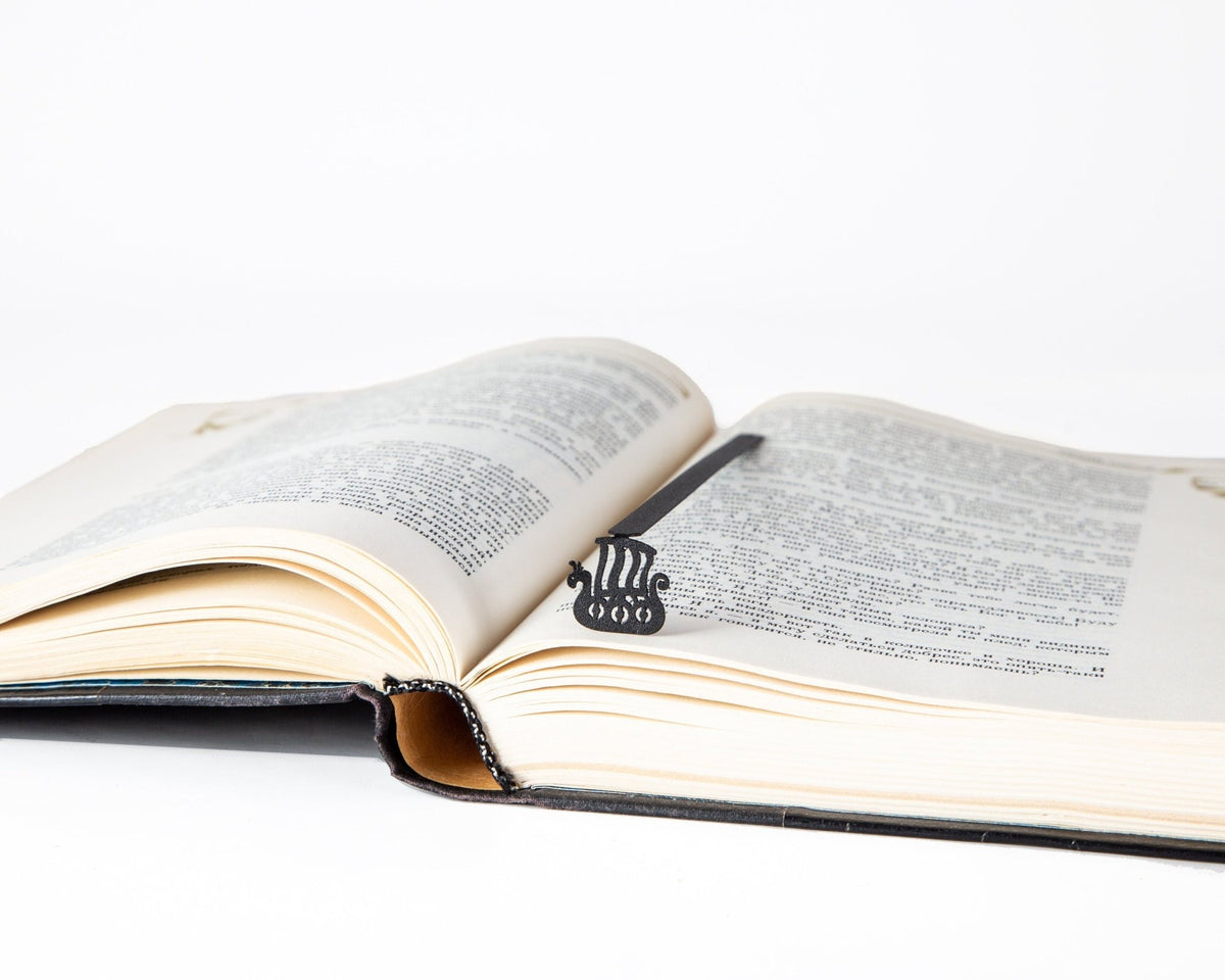 Scandinavian Vikings Ship metal bookmark marking a page in an open book
