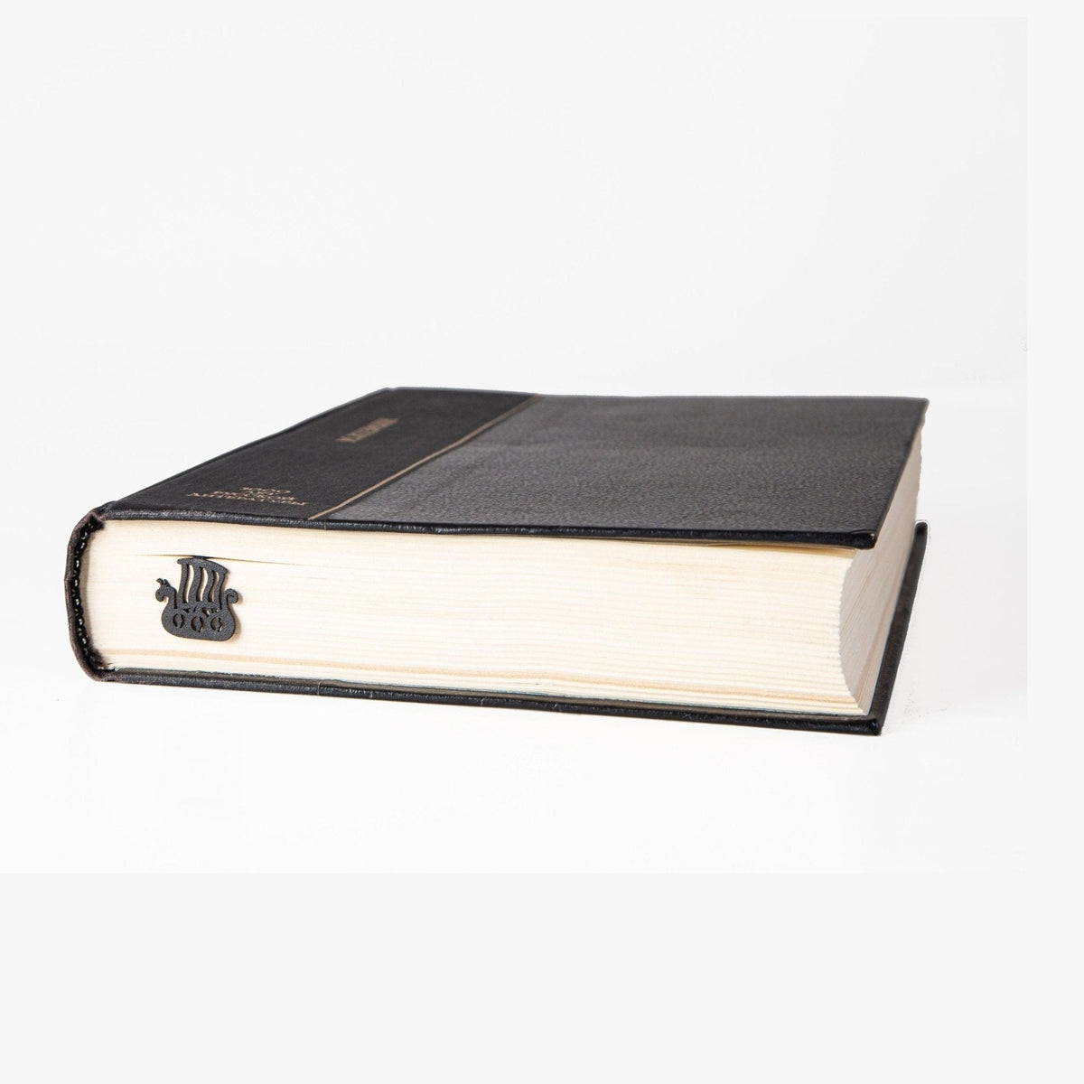 Scandinavian Vikings Ship metal bookmark in a closed book, only its top showing above the pages
