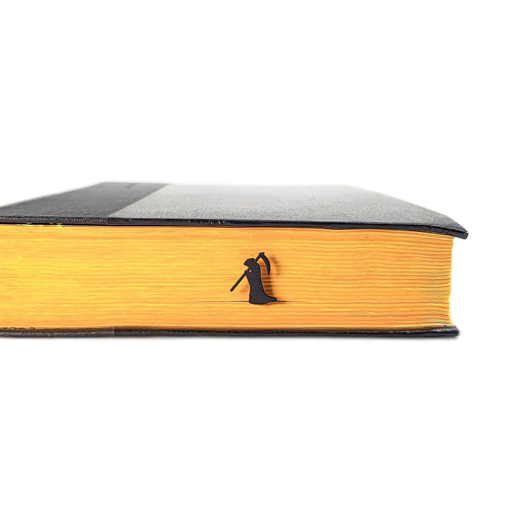 Grim Reaper metal bookmark in a closed book, only its top showing above the pages