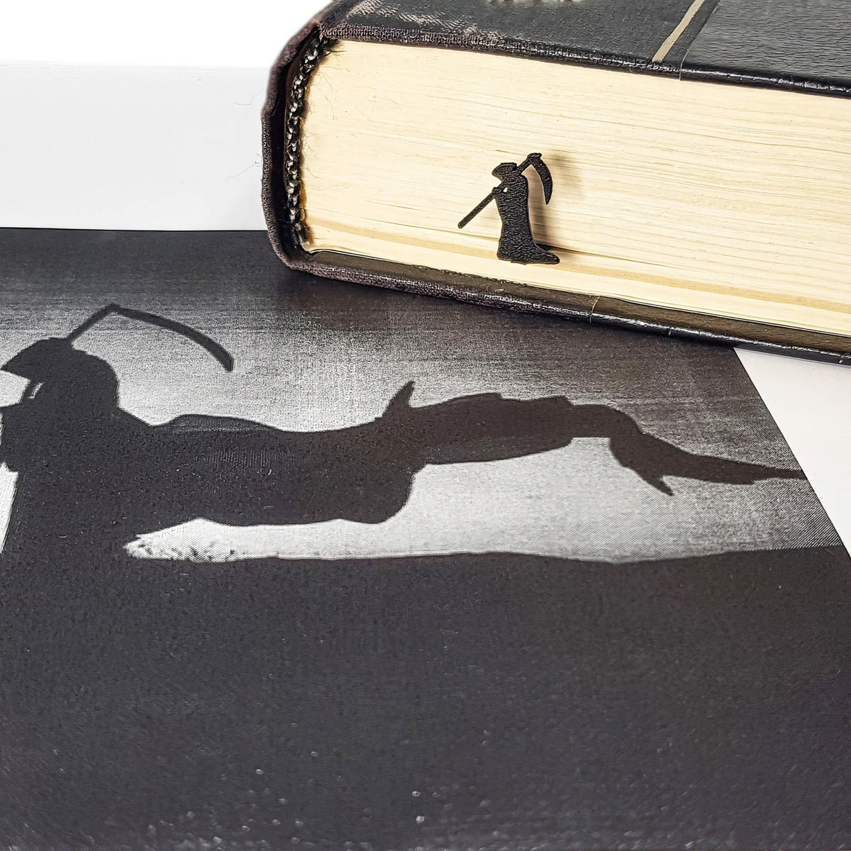 Grim Reaper metal bookmark placed on a colour illustration