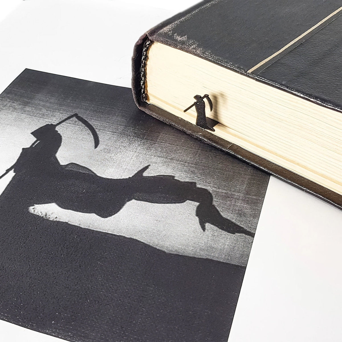 Grim Reaper metal bookmark marking a page in an illustrated book