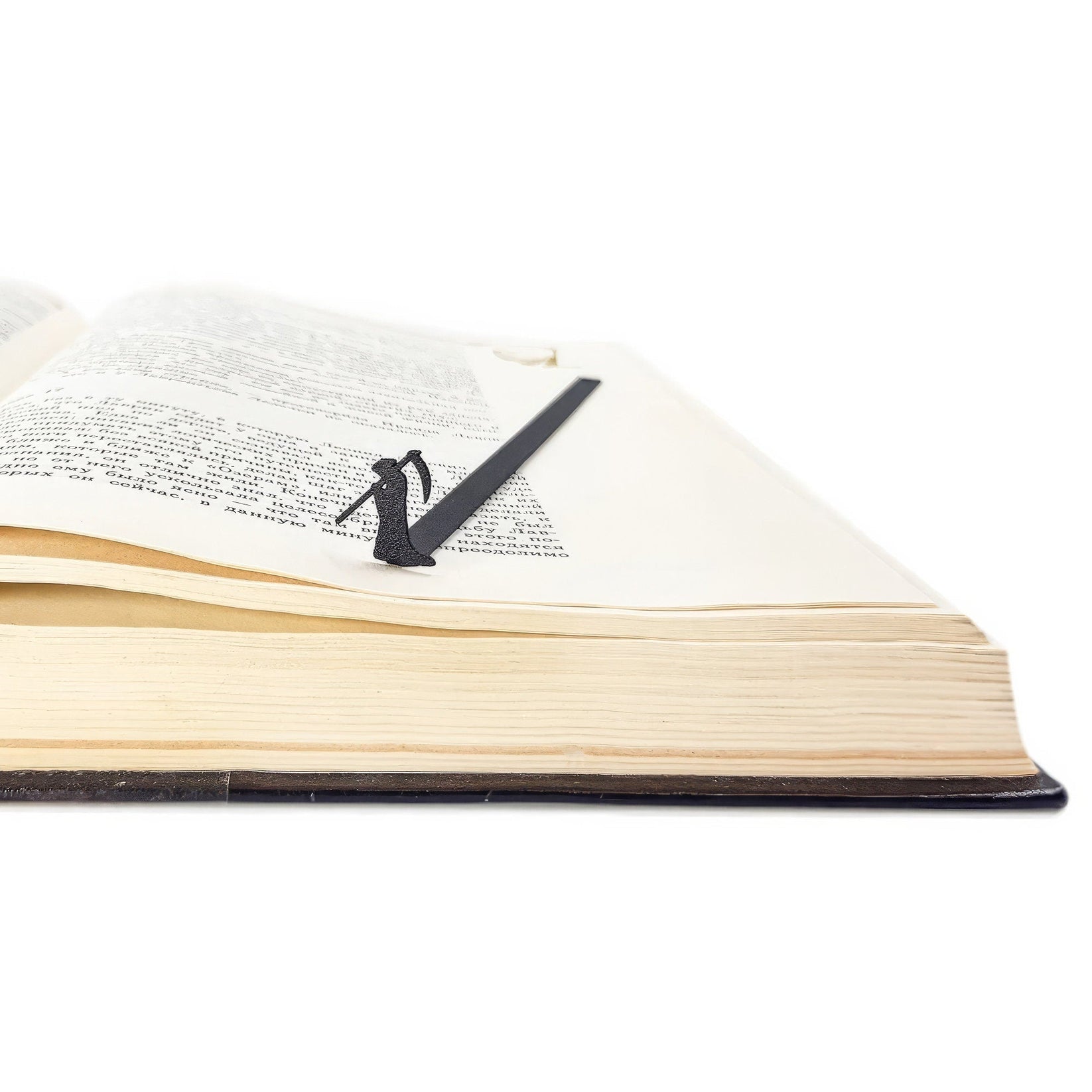 Grim Reaper metal bookmark lying across the pages of an open book