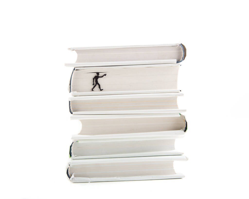 Zombies Are Coming metal bookmark shown with a stack of books