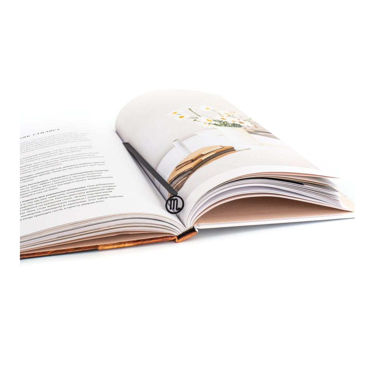 Scorpio metal bookmark resting on the pages of an open book