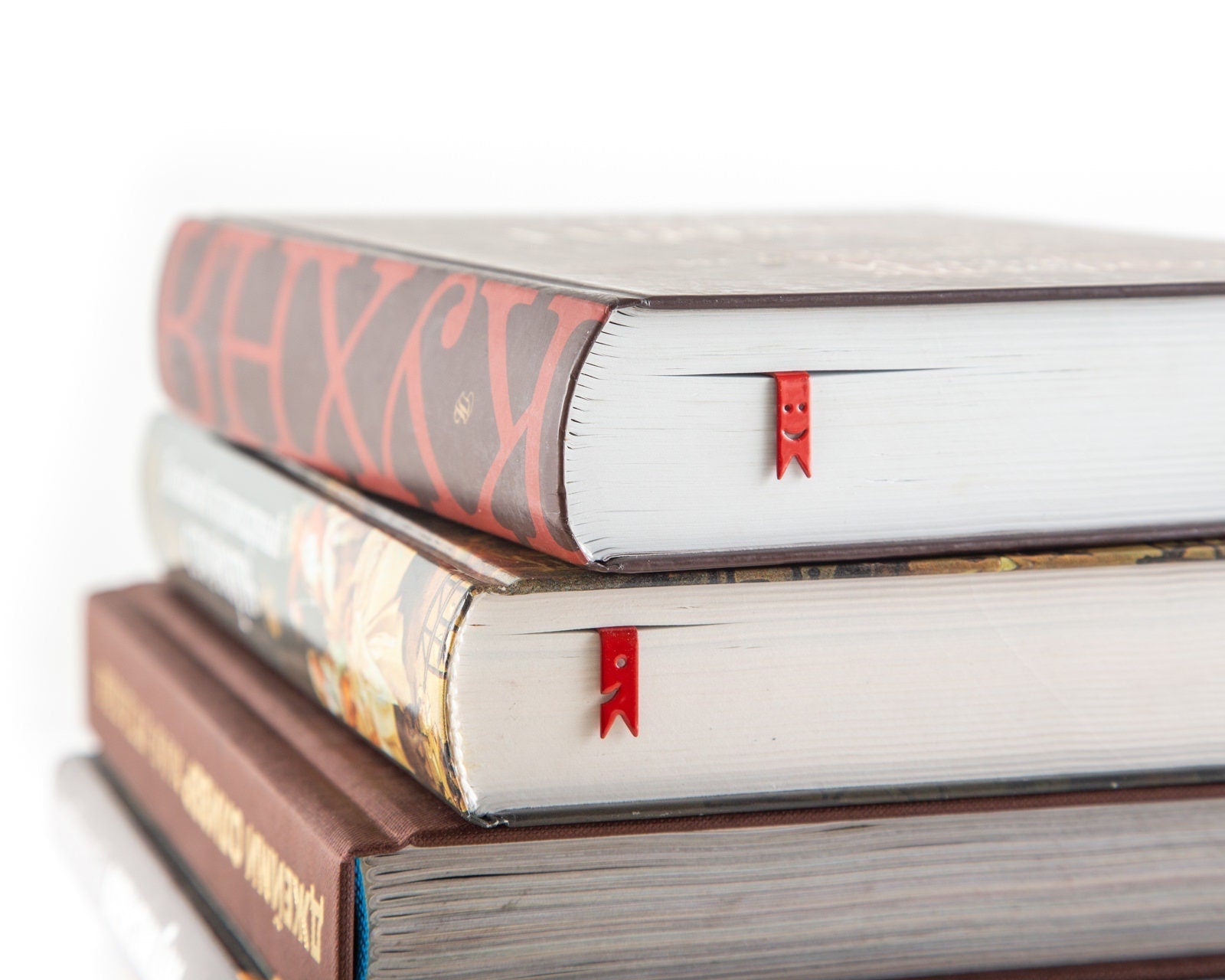 Smiling Ribbons Metal Bookmarks shown with a stack of books