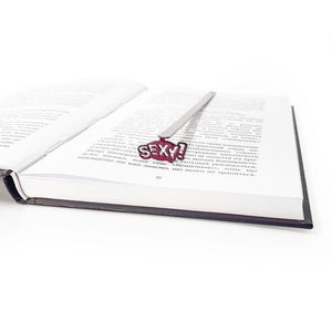 Sexy Smart metal bookmark resting between pages of an open hardcover book