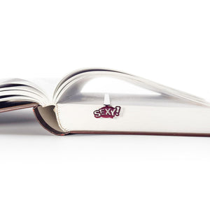 Open book with the Sexy Smart metal bookmark clipped over the page edge