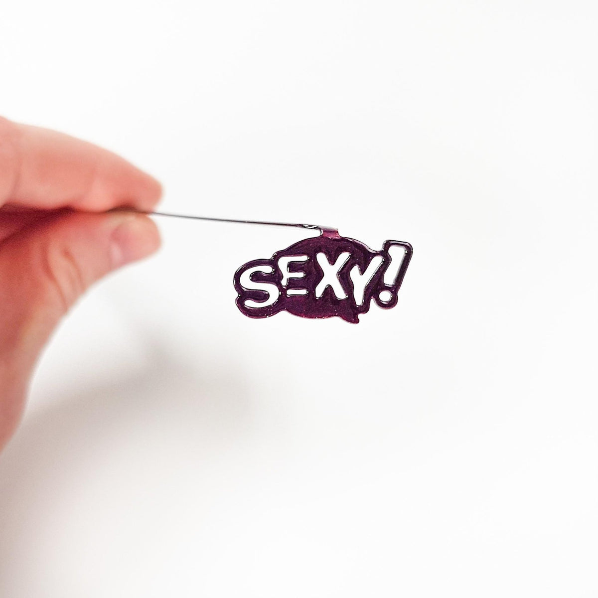 Sexy Smart metal bookmark held up beside an open book