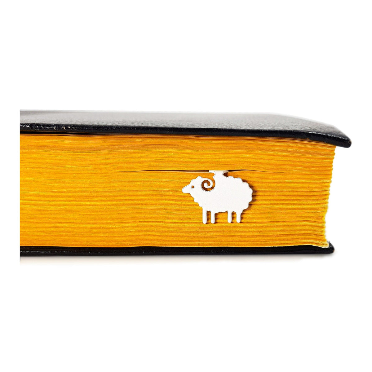 Sheep metal bookmark in a closed book, only its top showing above the pages