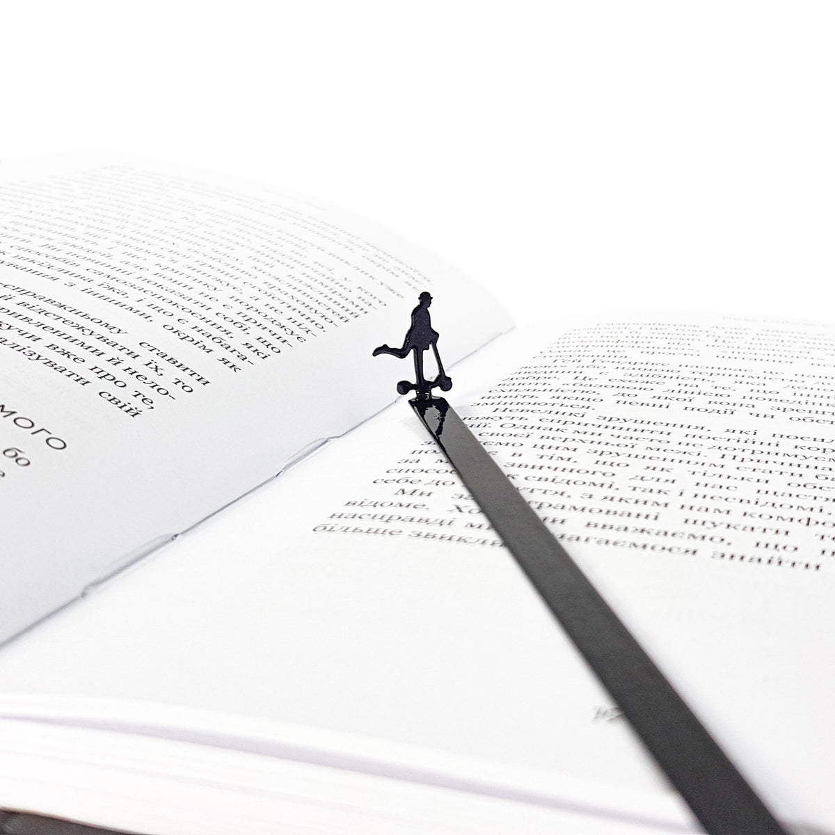 Skater Gentleman metal bookmark resting on the pages of an open book