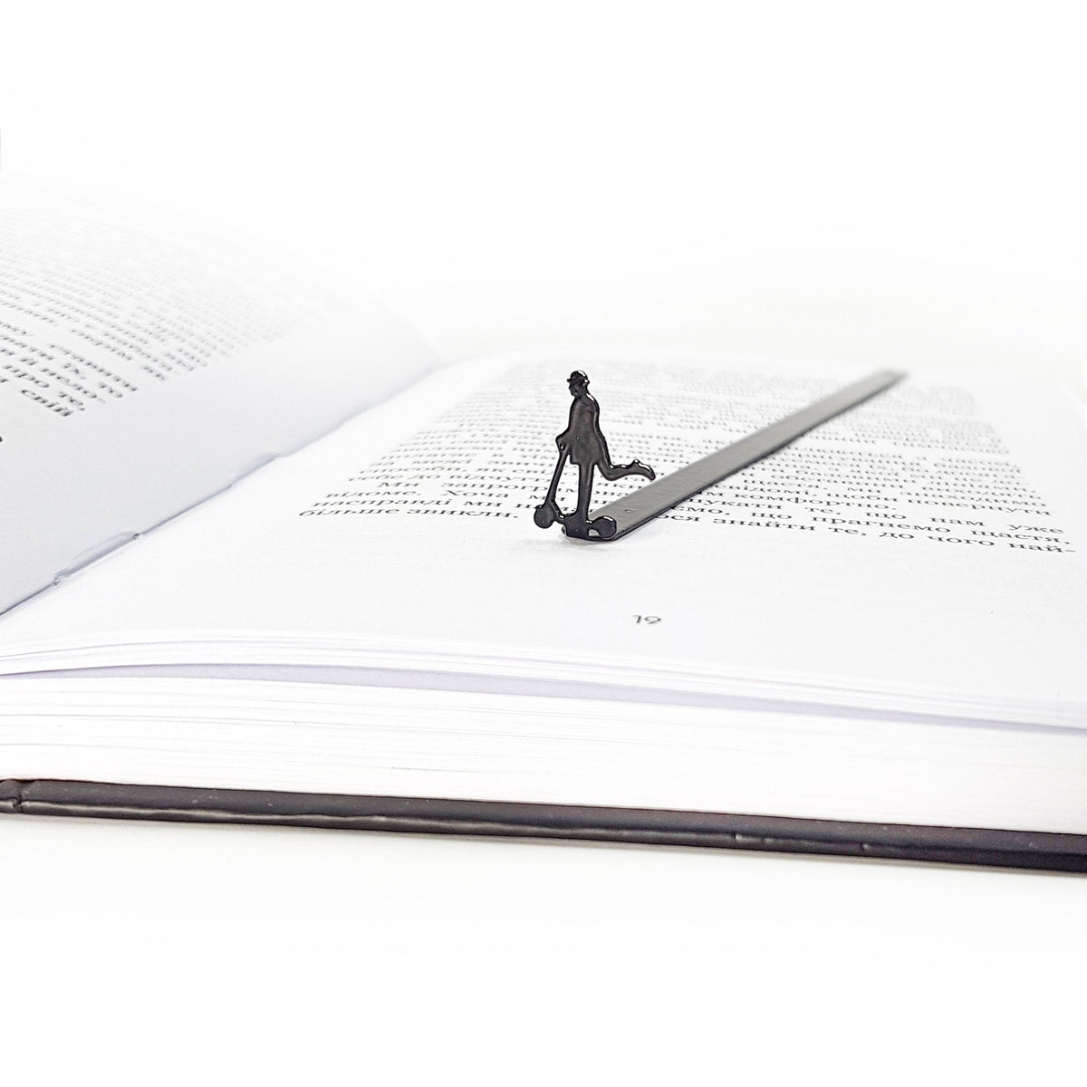 Skater Gentleman metal bookmark marking a page in an open book