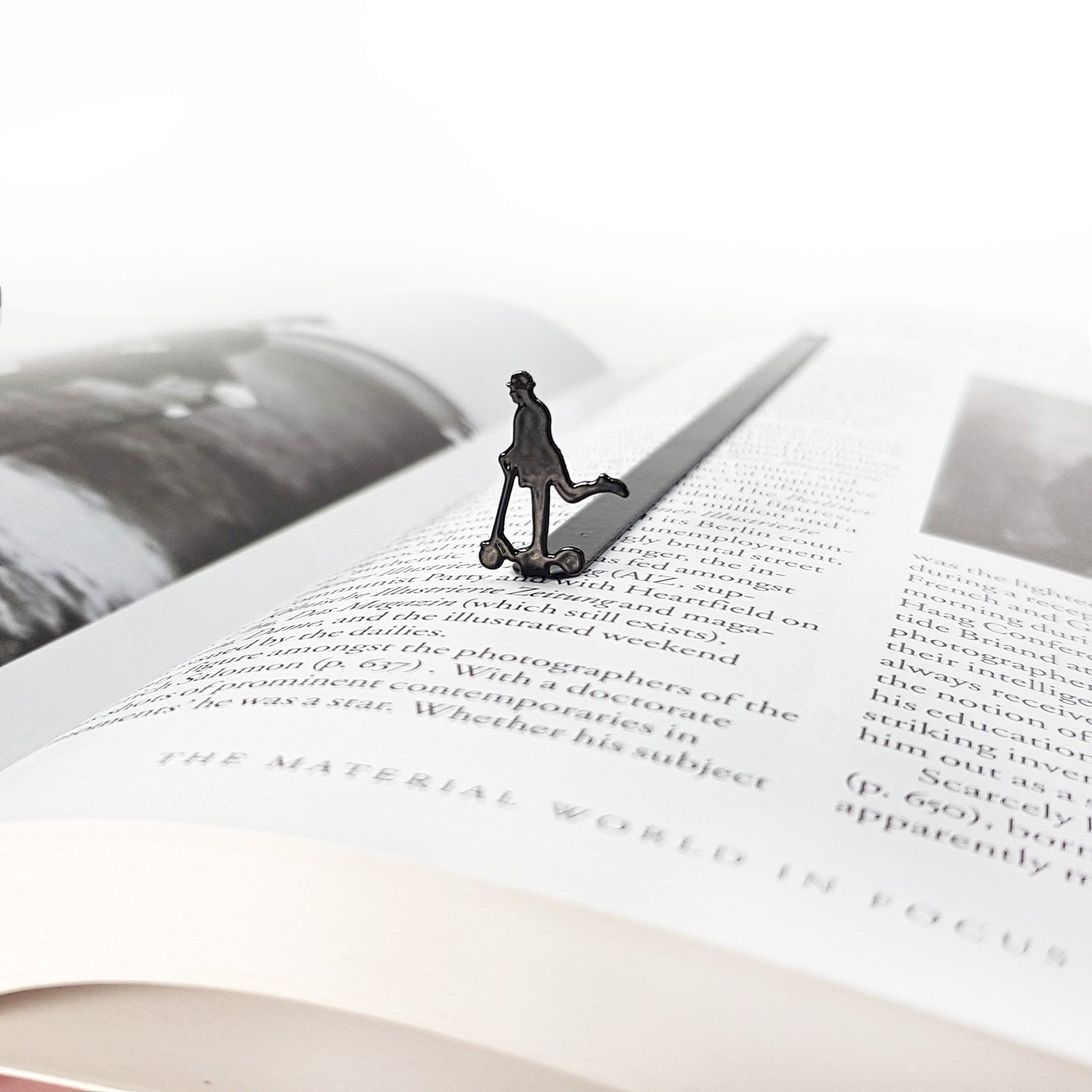 Skater Gentleman metal bookmark placed on a colour illustration
