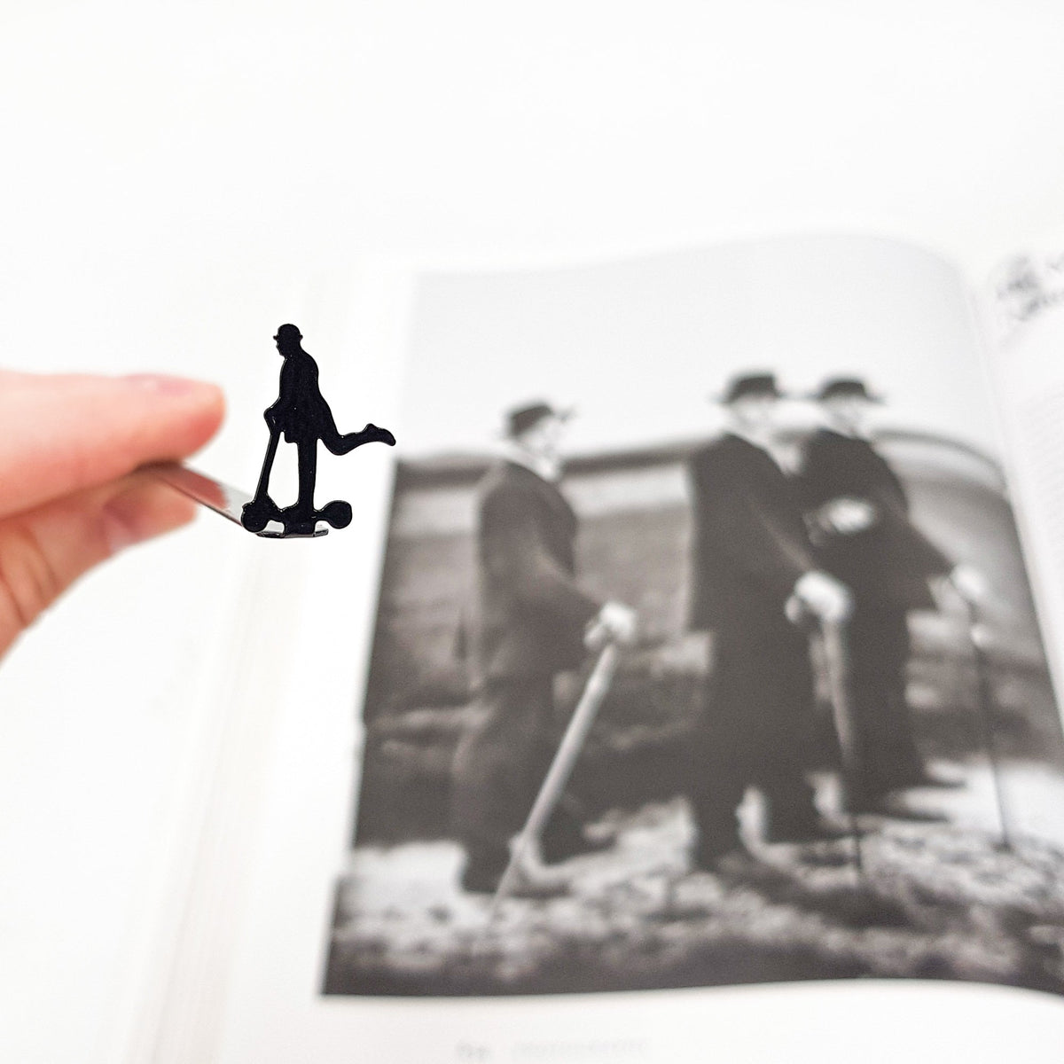Skater Gentleman metal bookmark marking a page in an illustrated book