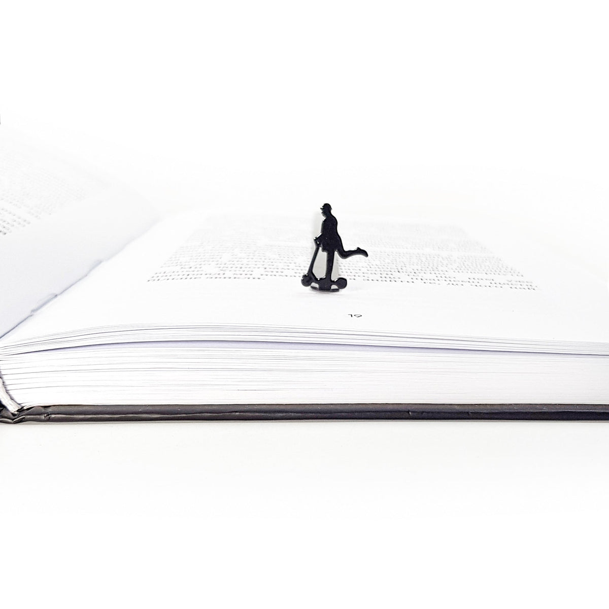 Skater Gentleman metal bookmark lying across the pages of an open book
