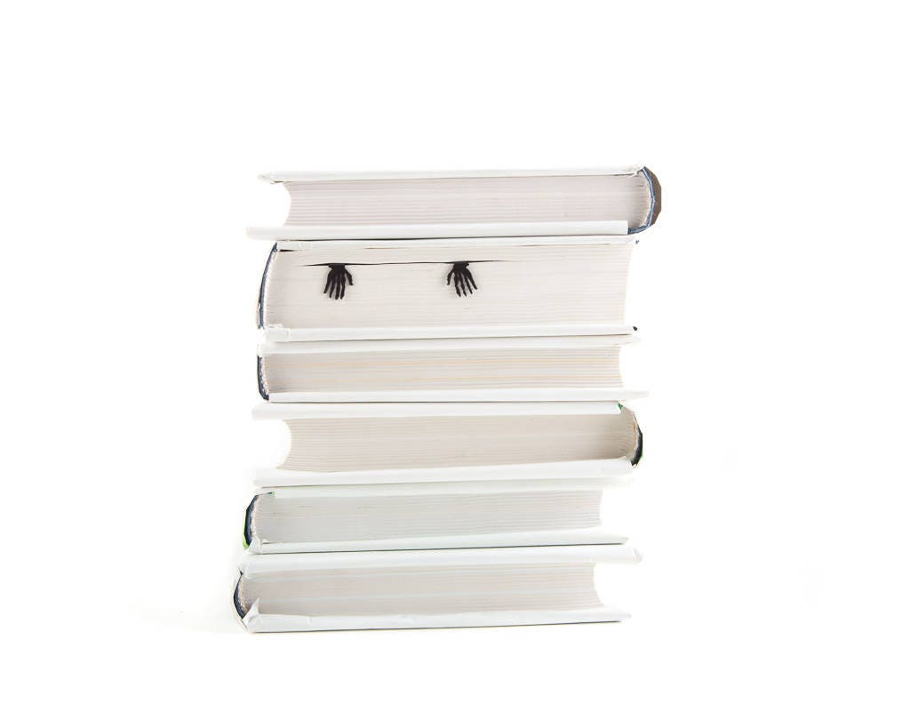 Skeleton in My Book metal bookmark shown with a stack of books
