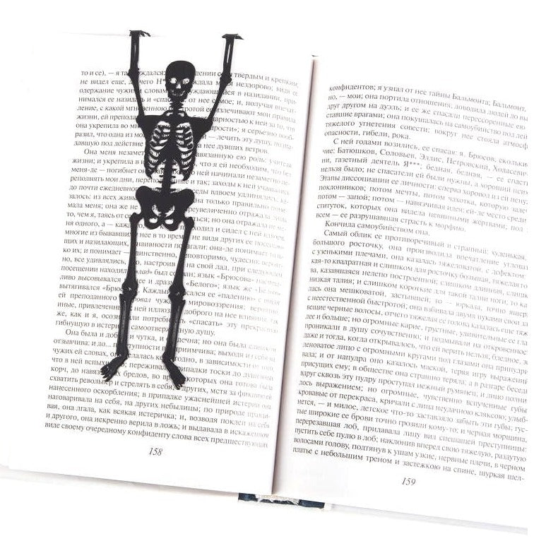 Skeleton in My Book metal bookmark resting on the pages of an open book