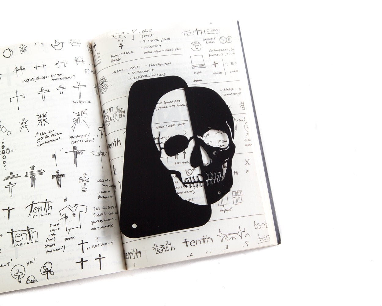 Skull Bookshelf Divider metal bookmark marking a page in a notebook