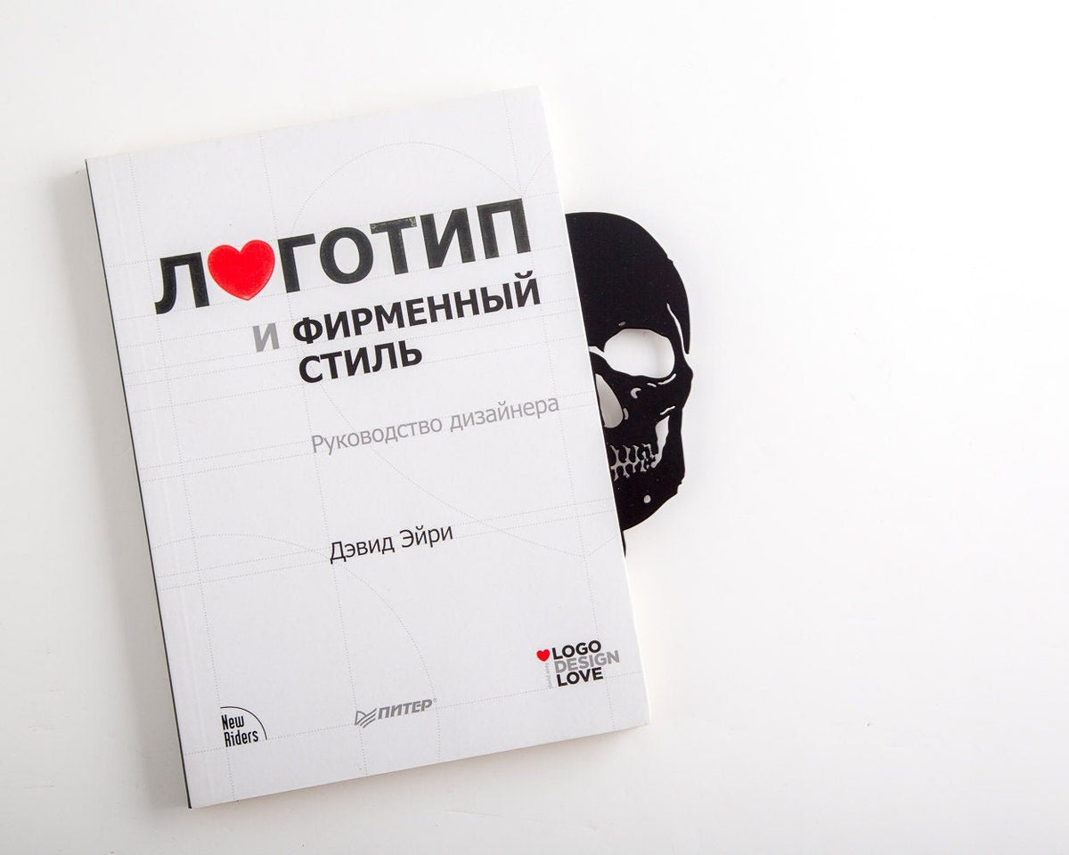 Skull Bookshelf Divider metal bookmark in a closed book, only its top showing above the pages