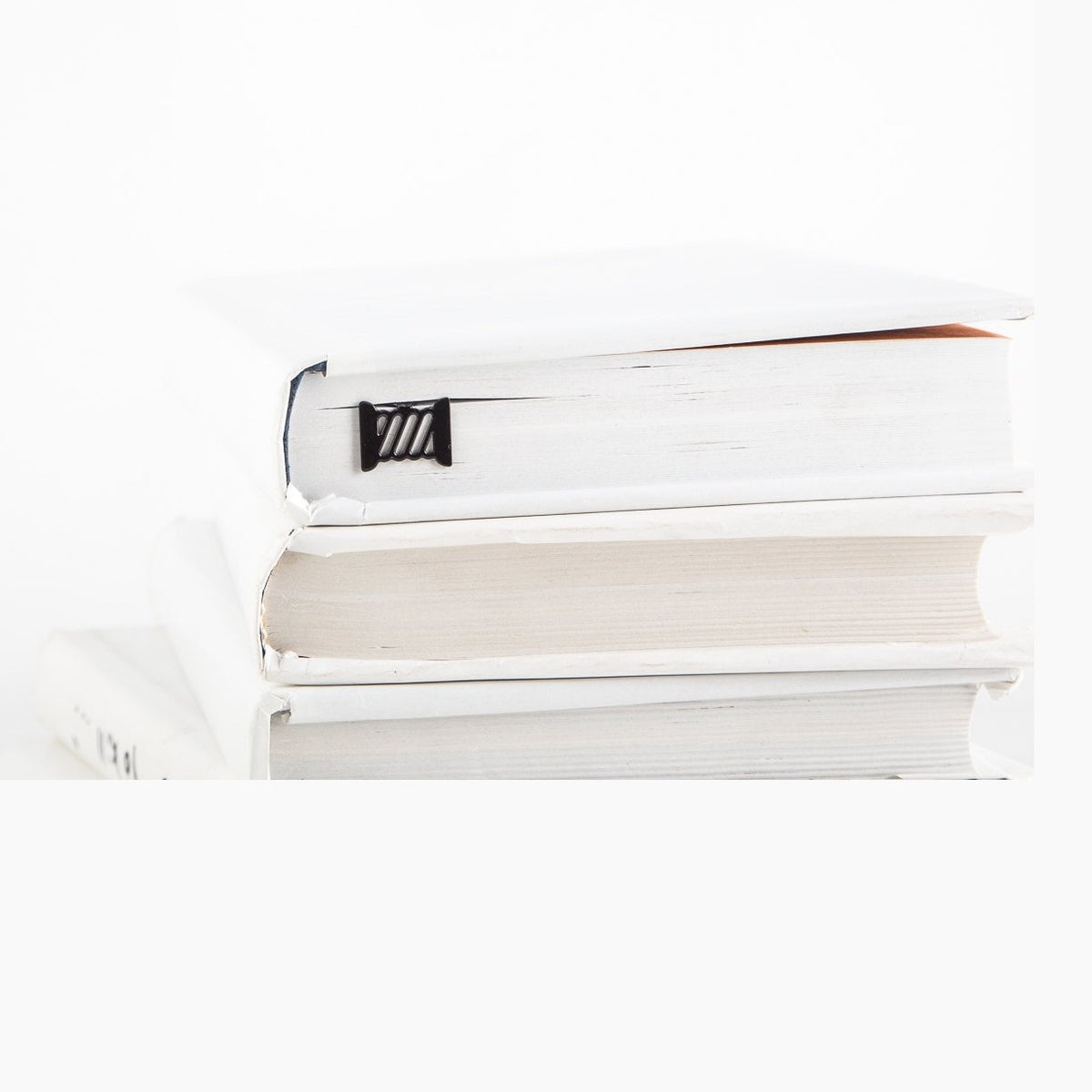 Spool of Thread metal bookmark shown with a stack of books
