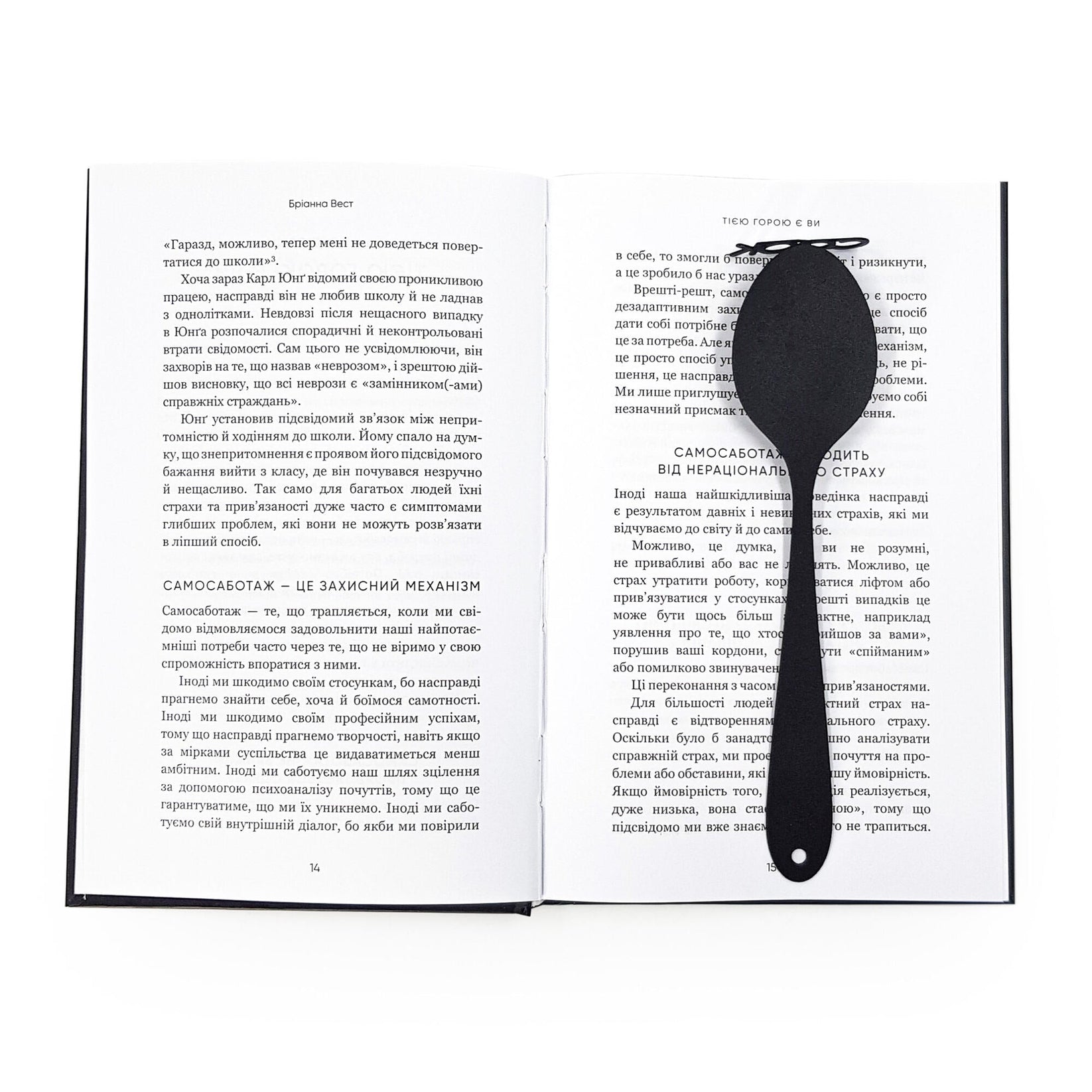 Spoon-Shaped metal bookmark resting on the pages of an open book